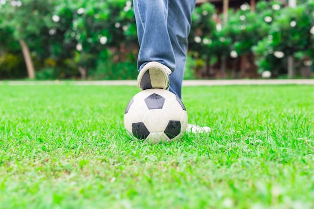 사진 남자는 그의 발을 사용하여 녹색 잔디에 공을 터치