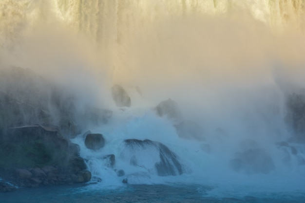 Фото Туман от брызг водопада. вода разбивается о камни