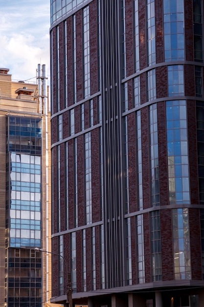 Фото Современный фасад офисного здания представляет собой абстрактный фрагмент с блестящими окнами в стальной конструкции. отличный фон для визитки, флаера, баннера с местом для надписи или логотипа