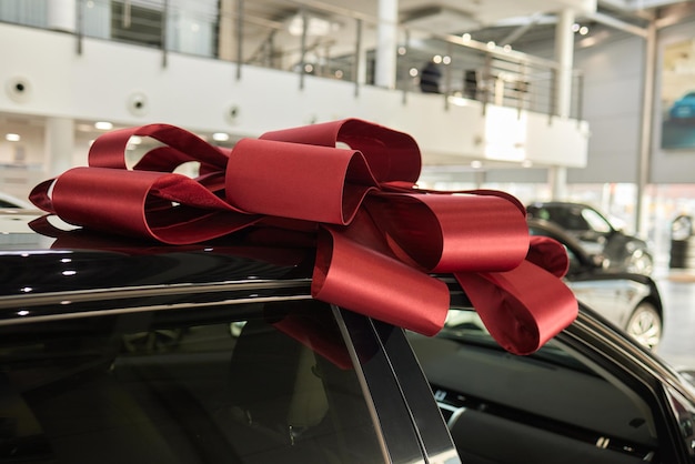 Фото Новая машина обернута красным луком прекрасная концепция подарка
