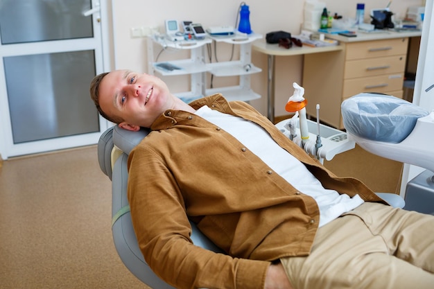 Фото Пациент лежит в кресле стоматолога и ждет врача. современный стоматологический кабинет