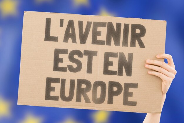 사진 the future is europe이라는 문구는 배경에 흐릿한 유럽 연합 국기가 있는 남성의 손에 있는 배너에 있습니다. eu 정치 커뮤니티 단결 사회 파트너십 강력한 강력한 경제