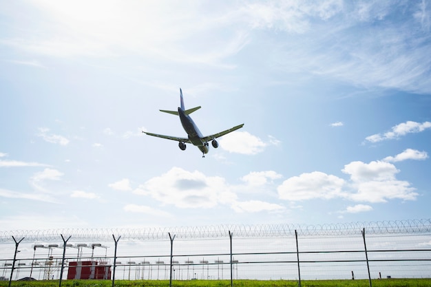 飛行機は明るい青空を背景に空港の滑走路に着陸します。