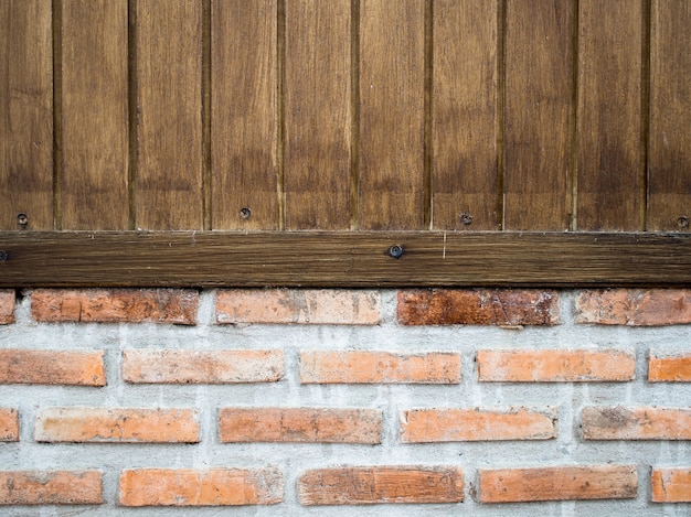 写真 板の木製の壁は古いレンガの壁にあります