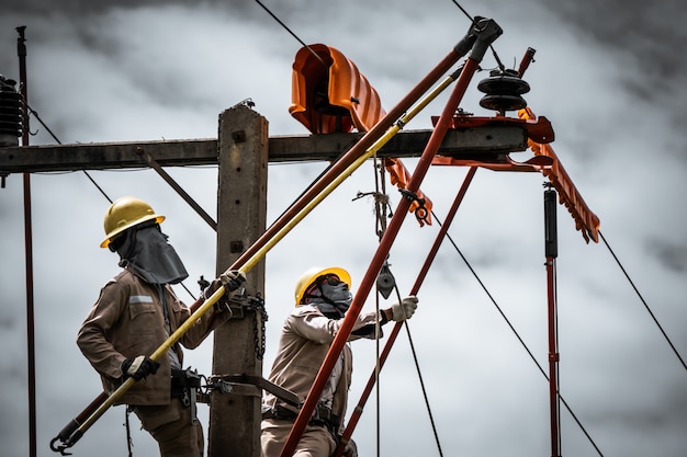 写真 電源ラインマンは、破損した絶縁体を交換しています