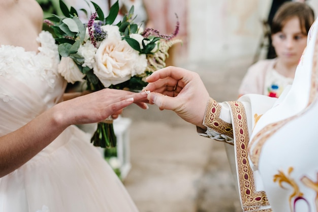 신부는 교회에서 신부와 신랑의 결혼 반지로 손을 축복합니다