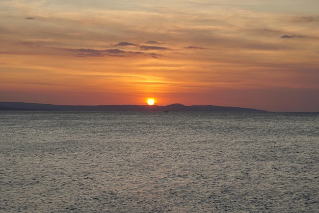 写真 インドネシアのセマウ島の後ろに沈む夕日