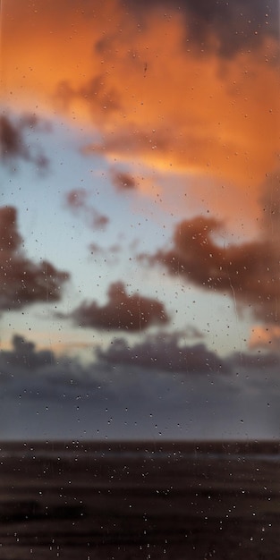 写真 ぼやけた背景に窓ガラスのビーチと海の水滴のテクスチャー