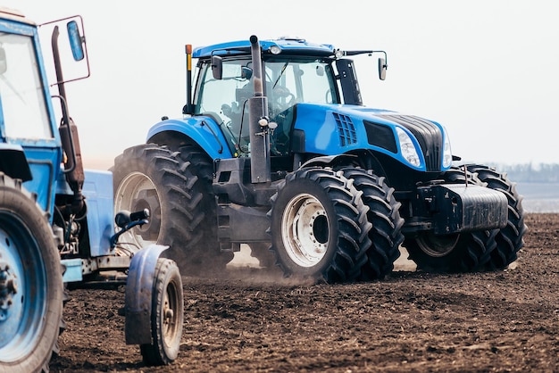 Фото Трактор обрабатывает поле весной комбайн в работе по посеву пшеницы и зерновых xa