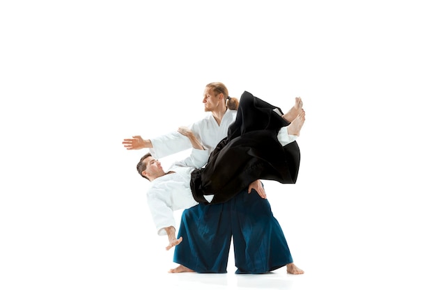 Фото Двое мужчин сражаются на тренировках по айкидо в школе боевых искусств.
