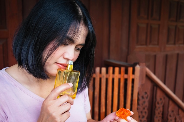 女性は彼女の香水の香りを吸い込んでいます。