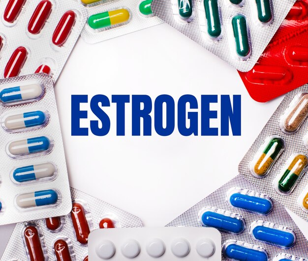 エストロゲンという言葉は、錠剤が入ったマルチカラーのパッケージに囲まれた明るい背景に書かれています。医療の概念
