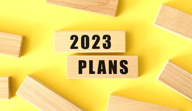 写真 黄色の背景に木製のブロックに「2023年計画」という言葉が書かれています