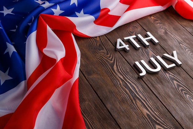 写真 7月4日 - アメリカ合衆国国旗が平らな構造の木製の背景に描かれています