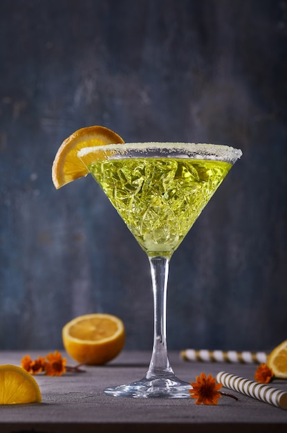 Liquore di thea al limone in un bicchiere da martini su un tavolo grigio