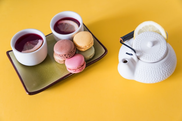 Thee met koekjes op een gele achtergrond. focus selectief.