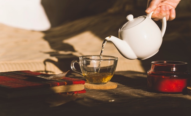 theeceremonie met een kopje koffie en een theepot op een houten tafel
