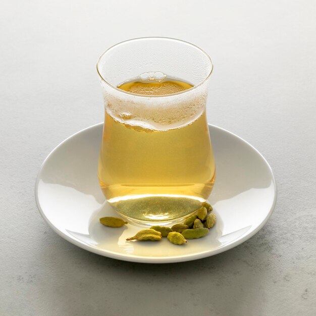 Foto theeglas met vers gemaakte hete cardamonthee en zaadjes