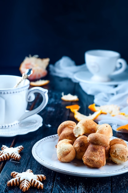 theekopje met thee en koekjes engel, mandarijn een zwarte tafel