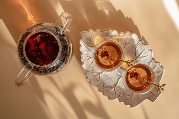 Foto theepot en glazen thee op een bladvormig dienblad ontbijt op de solcie morning close-up bovenaanzicht