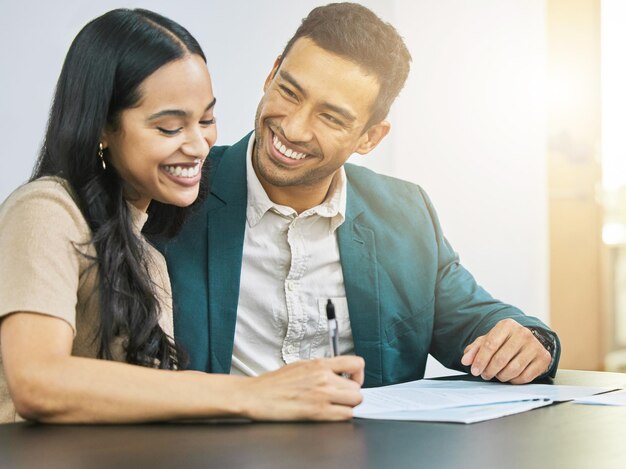 Their budget is beyond healthy Cropped shot of an affectionate young couple signing some financial paperwork