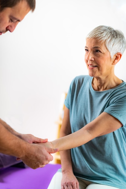 Therapeut controleert de arm van oudere vrouwen