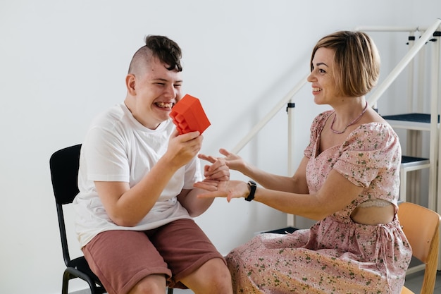 Therapeut die ontwikkelingsactiviteiten doet met een jongen met hersenverlamming