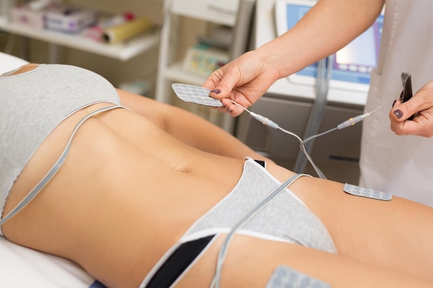 Photo therapist applying lipomassage on girls body in spa