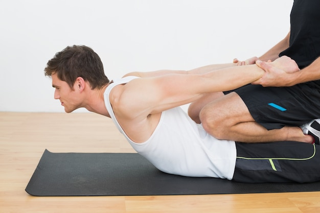 Therapist assisting young man with stretching exercises