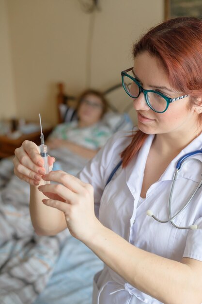 Therapist gives an intramuscular injection to an elderly woman A nurse holds a syringe with medicine for a senior citizen