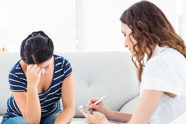 Therapist listening her patient and taking notes