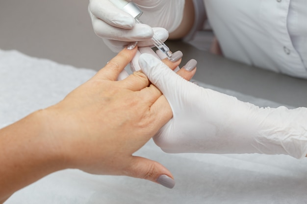 Therapist lubricating hands of a woman in a beauty salon