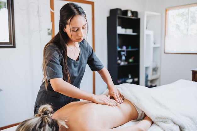 Терапевт делает массаж спины и шеи пациентке Оздоровительный центр спа Уход за кожей
