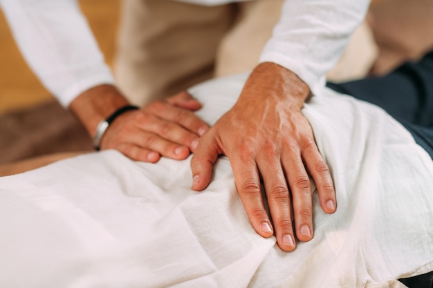 Foto terapeuta che massaggia la schiena di una donna che riceve un massaggio shiatsu alla schiena