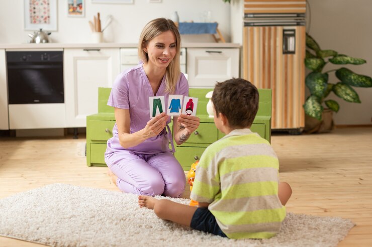 The therapist plays an educational game with the child using logic cards