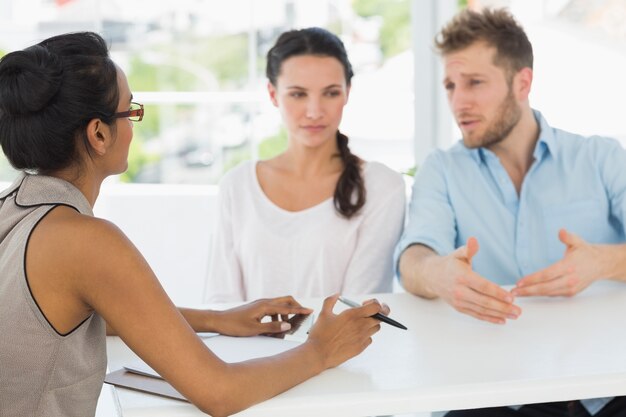 Therapist speaking with couple sitting at desk