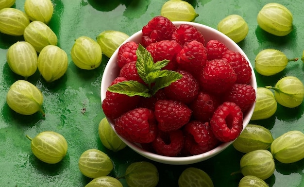 There are raspberries and gooseberries on the table