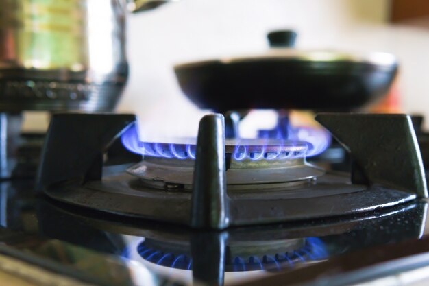 Foto c'è un fuoco blu che brucia sul fornello a gas nero in cucina