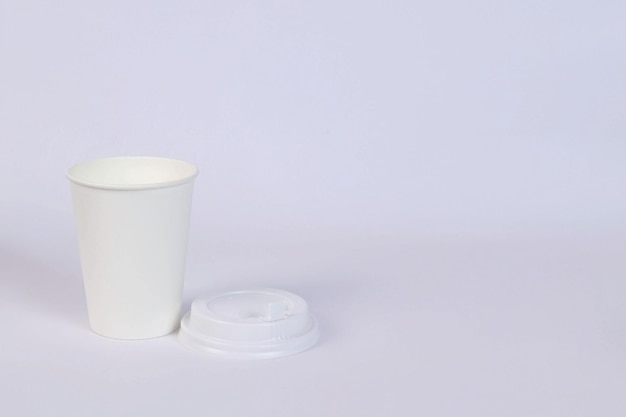 there is a glass, a lid lies next to it on a white background