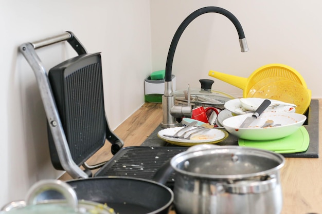 There is a lot of dirty dishes in the kitchen sink Dirty dishes and unwashed kitchen appliances