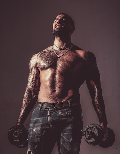 There is no limit to perfection Macho confident face with muscular body sportsman bodybuilder Muscular macho six packs hold dumbbells Guy attractive working out Muscular torso Work out concept