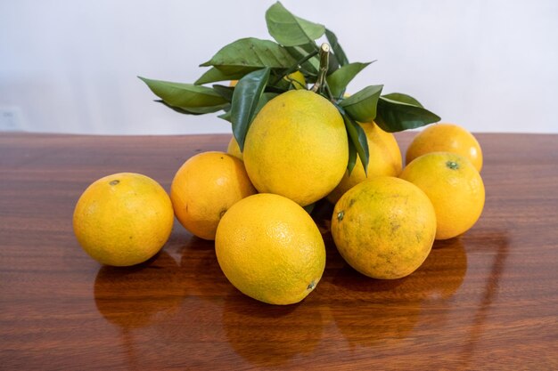 There is a plate of oranges on the table and there is also a reflection