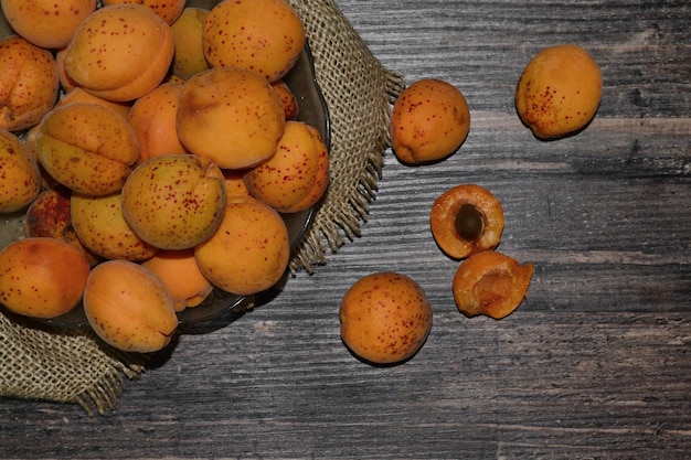 there is a plate with apricots on burlap on the table