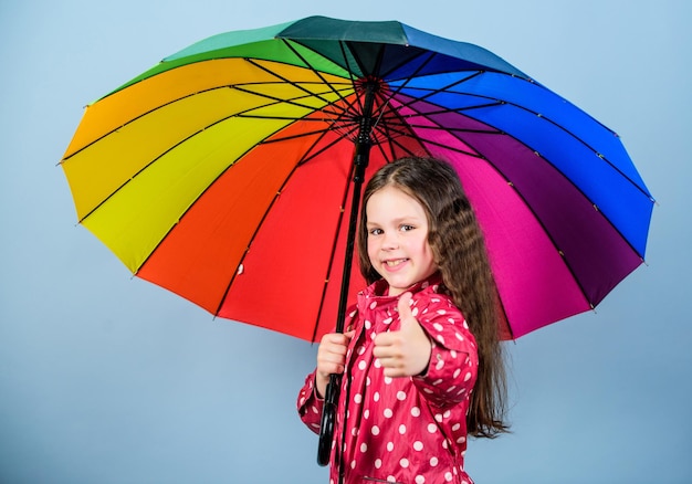 비가 온 후에는 항상 무지개가 있습니다. 적절한 옷을 입고 비오는 날씨 비오는 날 재미 우산 아래에서 행복한 산책 비 개념을 즐기십시오 가을 시즌 Kid girl happy hold 화려한 무지개 우산