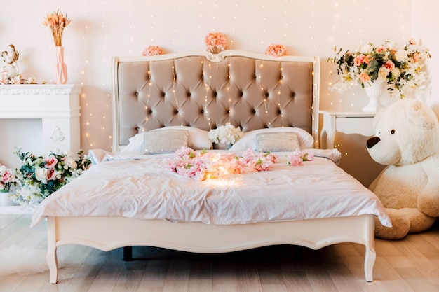 ロマンチックな花が咲く明るい部屋に柔らかいベッドがあります