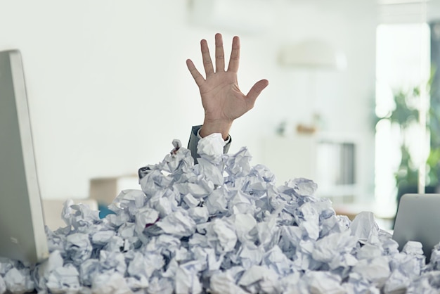 Theres a light at the end of the admin tunnel Shot of an unidentifiable businessman drowning under a pile of paperwork in the office