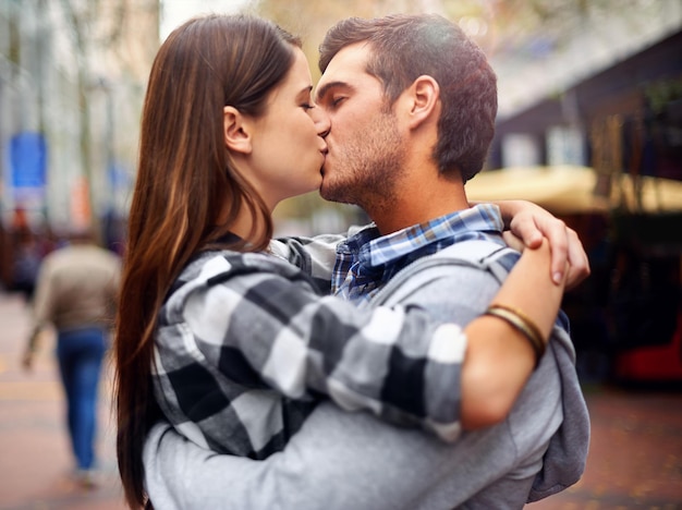 Non c'è mai un brutto posto per un bacio inquadratura di una giovane coppia che si bacia in una strada del centro