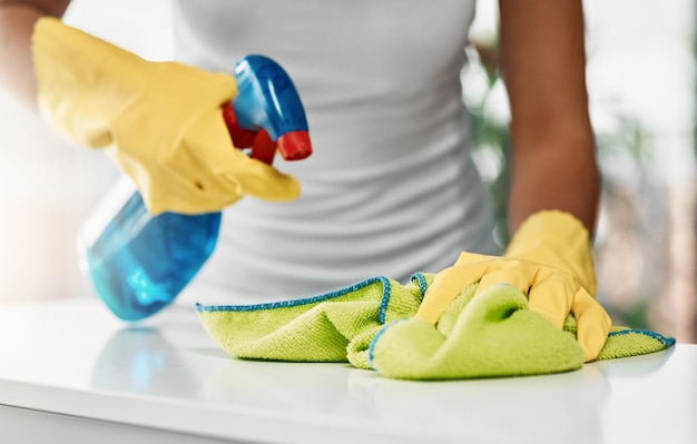 Theres no room for germs here Cropped shot of an unrecognizable young woman cleaning a table at home