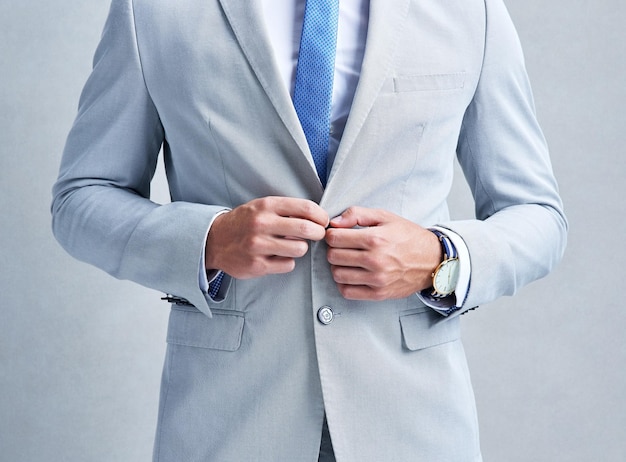 写真 灰色の背景にポーズをとっている灰色のスーツを着たビジネスマンの最初のスタジオショットだけの第二印象のようなものはありません
