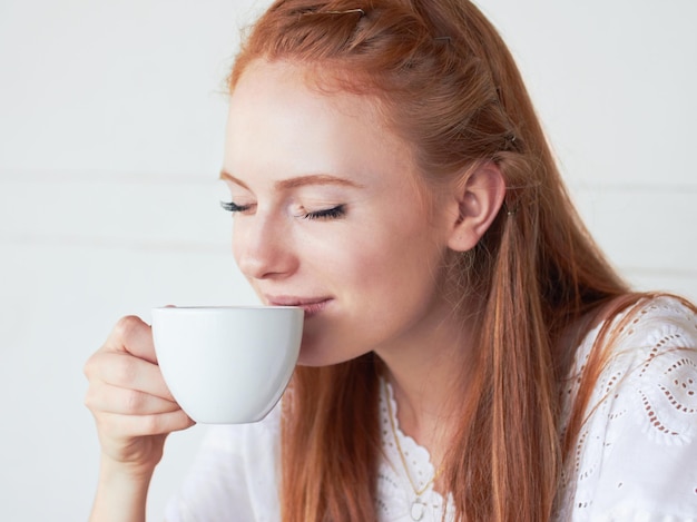 朝の淹れたてのコーヒーに勝るものはありませんカフェでコーヒーを飲む若い女性のクロップドショット